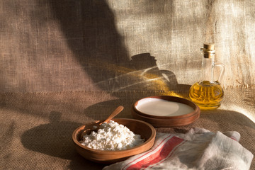 cottage curd and sour cream in wooden plate on a linen tablecloth and place for text
