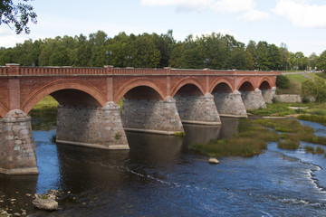 Fototapeta premium old Brick bridge across the River Venta in the city of Kuldiga Latvia
