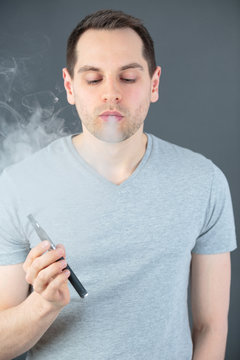 young man vaping - electronic cigarette concept
