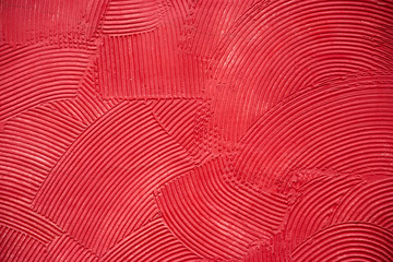 Red artistic handcraft circular pattern on cement wall