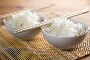 Zwei Schalen Basmati Reis mit Stäbchen auf Matte