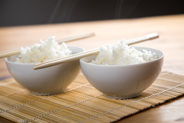 Zwei Schalen Basmati Reis mit Stäbchen auf Matte