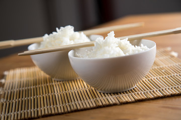 Zwei Schalen Basmati Reis mit Stäbchen auf Matte