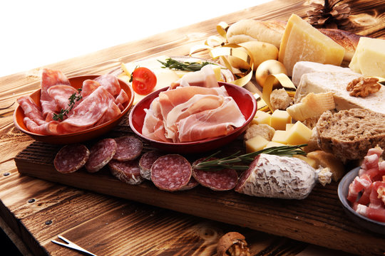 assorted cheese,meats and bread on wooden background