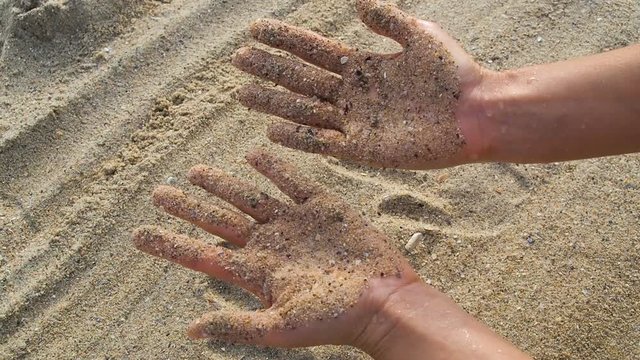 Wet hands in the sand. Handprints in the sand.
