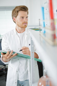 scientist in laboratory taking notes