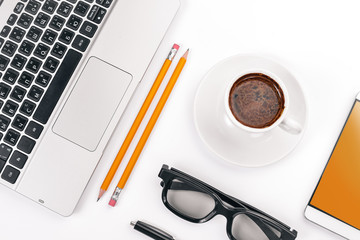 White Office Desk. Laptop, phone, cup of coffee, glasses, pen, pencil. On a white background. Top view. Free space for text.