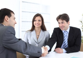 handshake business partners in the workplace