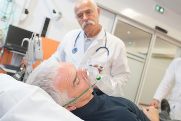 Fototapeta na wymiar doctor examining his patient wearing oxygen mask