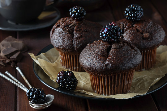 Chocolate muffins decorated with blackberry.