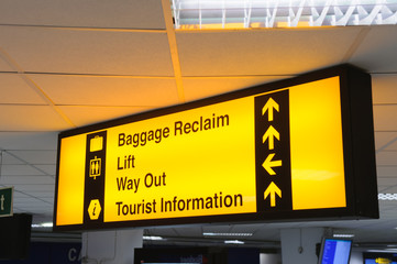 Airport sign giving directions to baggage reclaim, lift, way out and tourist information