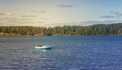 A fisherman who was fishing in a boat on big wood lake at sunset
