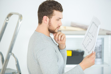 man looking at house plans before work