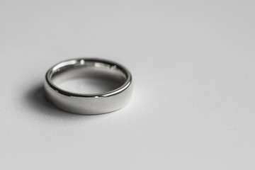 Silver metal wedding ring shot against a white background.