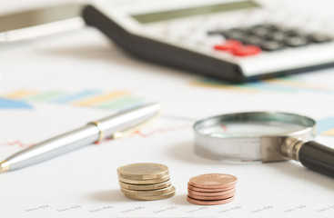 euro coins stack on the table with calculator and magnifier