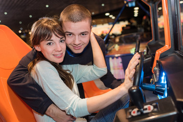 Fototapeta na wymiar young couple cuddling in race car simulator