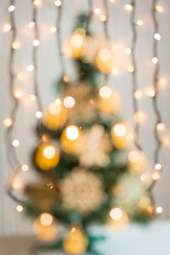 Christmas background with bokeh defocused decorated Christmas tree and glowing lights garland
