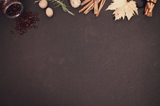 winter concept background coffee beans, cinnamon sticks, dry leaf, walnuts © OZKAN