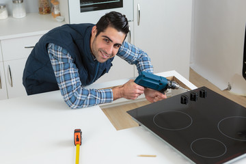 man fitting a kitchen stove