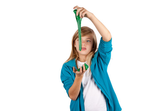 Cute girl playing with green slime. Isolated on white background.