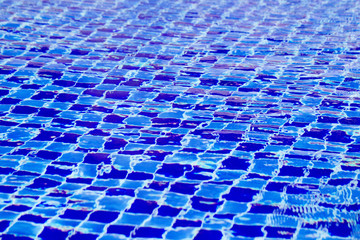 Abstract background from blue tiled pool with clear rippling water