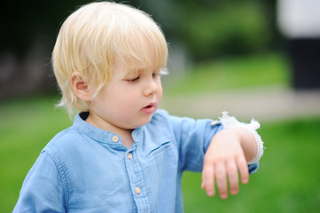 Cute little boy looking on his elbow with applied bandage
