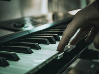 Obraz premium macro shot hand playing on the synthesizer piano keys