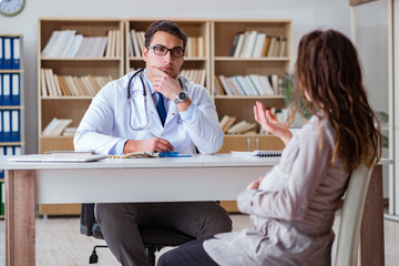 Obraz premium Pregnant woman visiting doctor for consultation