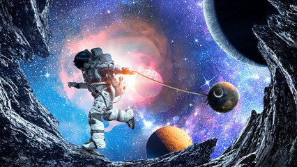 Obraz na płótnie Canvas Fantasy image with spaceman catch planet. Mixed media