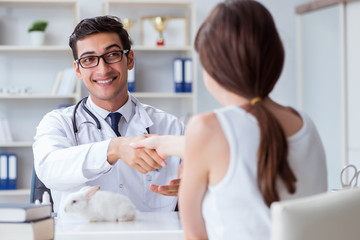 Woman with pet rabbit visiting vet doctor