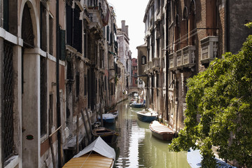 Fototapeta na wymiar View of boats on canal and old, typical, historical buildings in Venice / Italy.