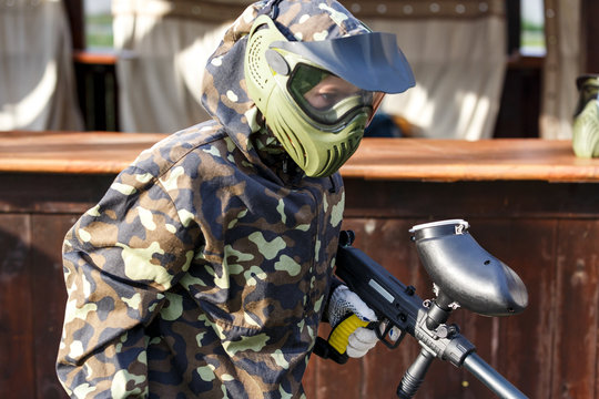 group of kids play paintball at summer field