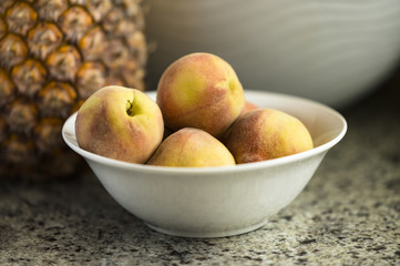 Peaches In Bowl Next To Pineapple