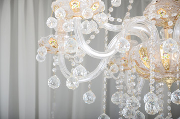 Close-up photo of the scenery on the old chandelier. Glass figures shine and reflect light with...