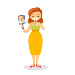 Young caucasian white woman doing makeup and looking in a mirror. Woman rouge lips with a lipstick. Woman applying lips makeup. Vector cartoon illustration isolated on white background. Square layout.