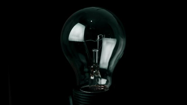 turn on and turn off,  retro vintage light bulb with tungsten technology built-in on black background, old style atmosphere concept