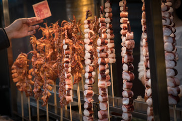 Chinese Street Good - Man Buying Octopus Tentacles in Xian China Selective Focus