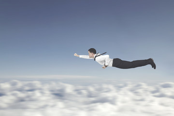 Male entrepreneur flying with a superhero pose