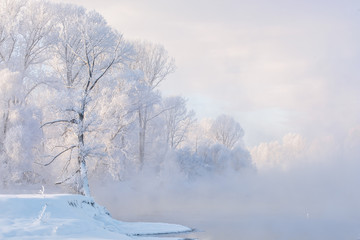 Fototapeta na wymiar Snowy frozen landscape of sunrise on lakeside with trees 