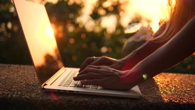 Close Up Woman Typing on Laptop Keyboard Againts Beautiful Beach Sunset. 4K, Slowmotion. Phuket, Thailand.