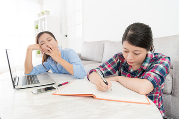 Naklejka premium sweet student doing homework seriously at home