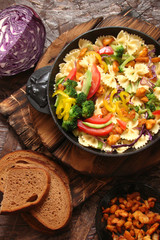 Farfalle pasta with slices of grilled chicken, sweet peppers, avocado, cabbage, broccoli, tomatoes and red cabbage