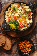 Farfalle pasta with slices of grilled chicken, sweet peppers, avocado, cabbage, broccoli, tomatoes and red cabbage