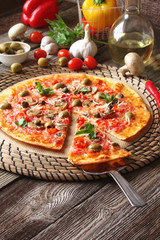 Pizza with tomatoes, mushrooms, black olives, Parmesan cheese, capers