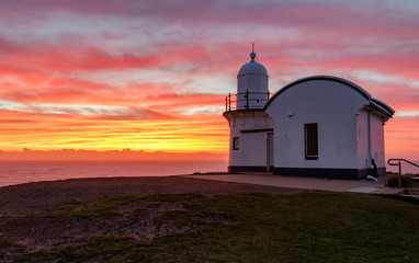Tacking point lighthouse at dawn, yellow and red