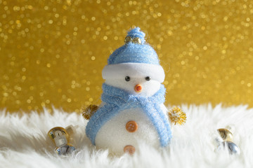 Happy snowman standing in gold winter christmas snow background. Merry christmas and happy new year greeting card with copy-space.