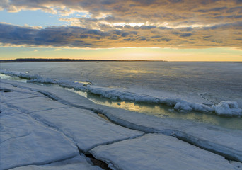  winter sunrise seascape with ice and colored sky.