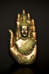 Buddha in hand on black background