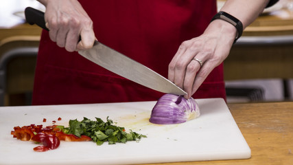 Close View of Red Onion Being Sliced by Woman