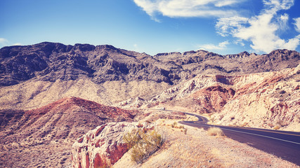 Vintage toned picture of a desert road in Valley of Fire State Park, Nevada, USA.
